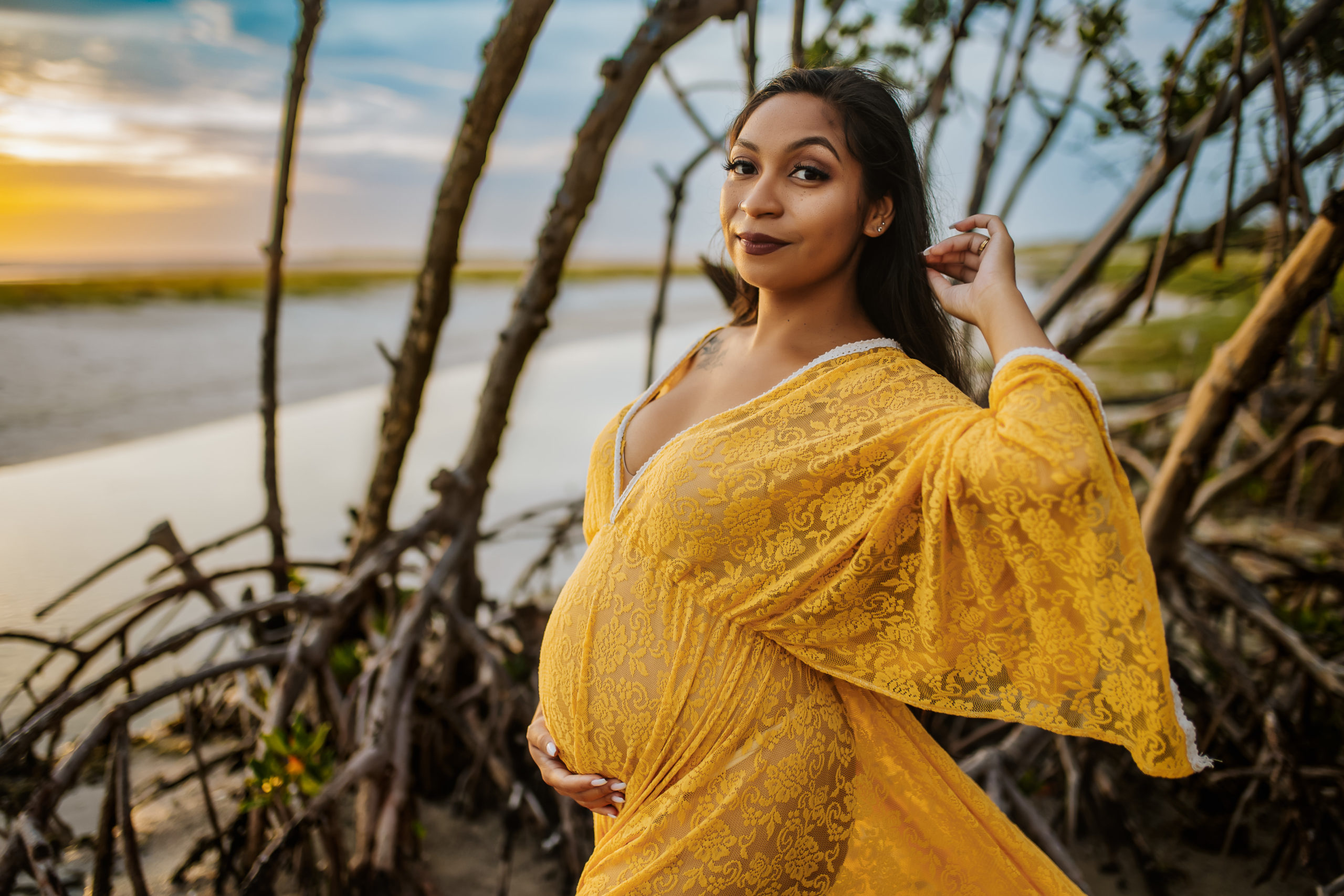 gorgeous beach sunset maternity session mother wearing a yellow lace boho dress at Fort Desoto beach 