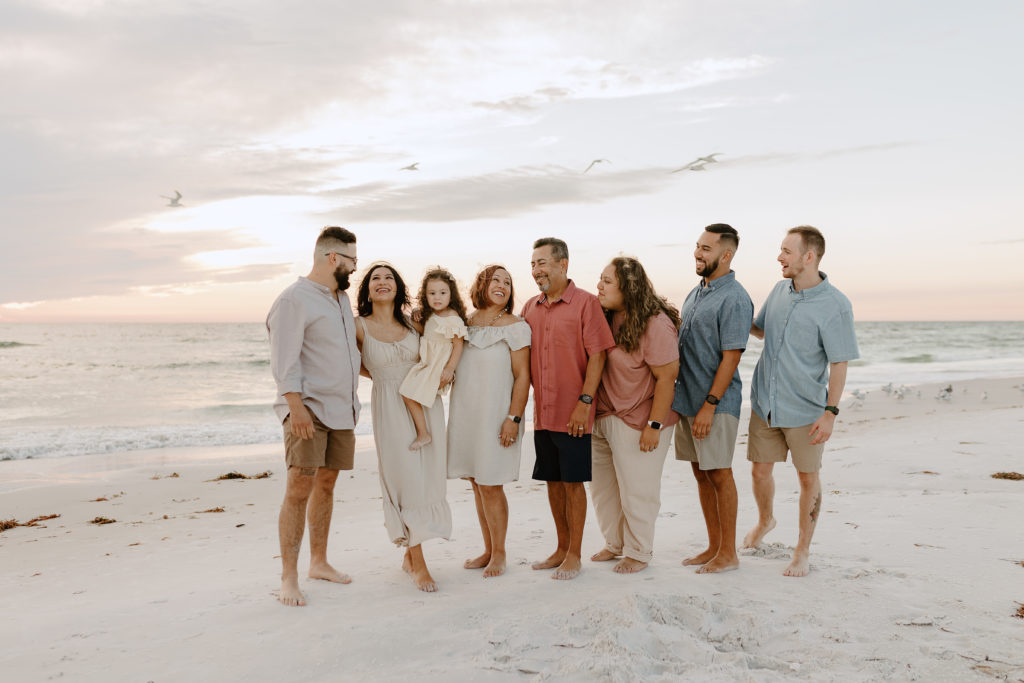 A family together on the beach at sunset by extended family photographer Michelle Medina.