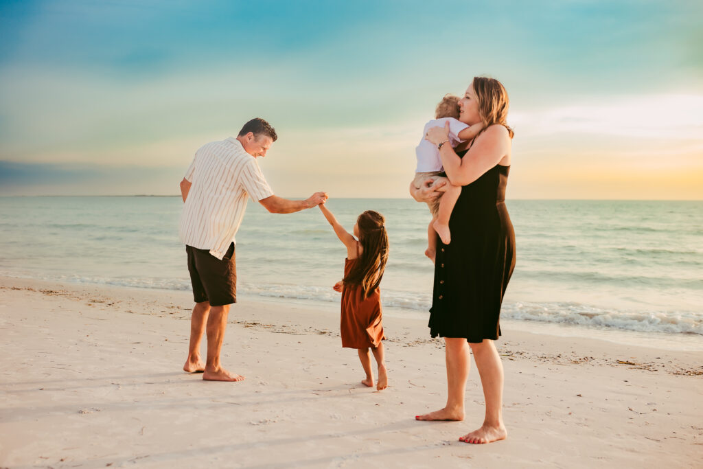 A family dancing at sunset on the beach by St. Pete Beach Photographer Michelle Medina. 